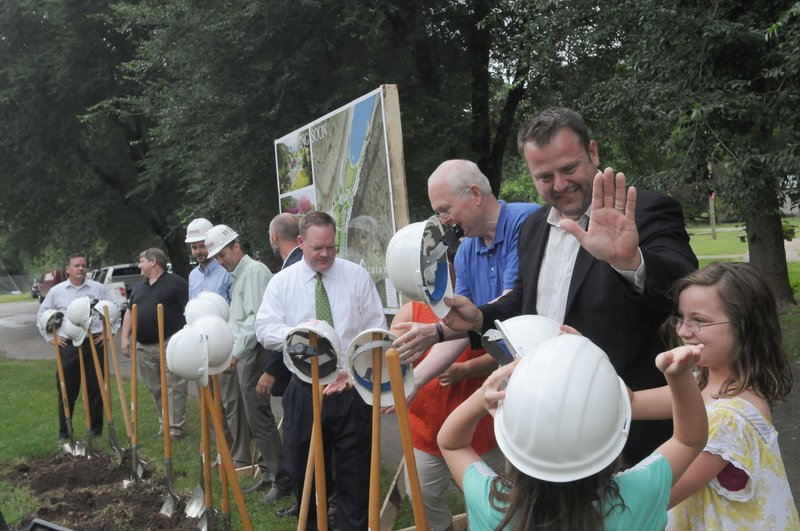 Ryan Hale with the Walton Family Foundation (right) high-fives his daughters Jaklyn, 8 (in hard hat) and Emily, 10 after groundbreaking festivities Wednesday July 22 2015 at Lake Atalanta Park in Rogers.