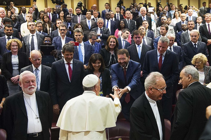 Pope Francis greets Rome Mayor Ignazio Marino as he meets mayors gathered in the Synod Hall at the Vatican during a conference Tuesday on climate change, human trafficking and modern slavery.