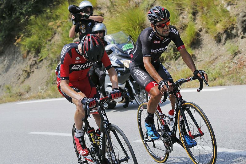 American Tejay van Garderen (left) struggles after falling ill during Wednesday’s 17th stage of the Tour de France. He eventually dropped out of the Tour while in third place overall.