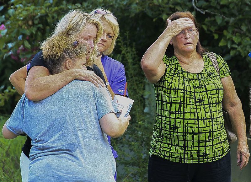 Family members wait for information from police outside a Quail Run Circle home in Conway, where the bodies of a couple whom one relative identified as Robert and Patricia Cogdell were found Wednesday. 
