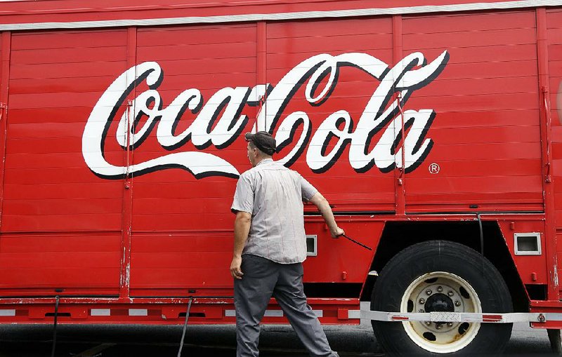 A deliveryman closes a compartment on a Coca-Cola truck on July 9 in Haverhill, Mass. Coca-Cola on Wednesday reported a quarterly profit of $3.11 billion. 