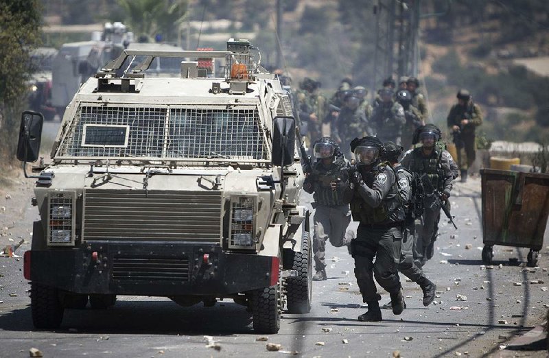 Israeli soldiers clash with Palestinians after the funeral Thursday for Falah Abu Marya in Beit Ommar on the West Bank.