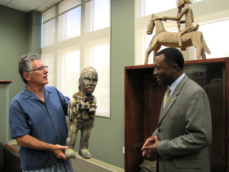 Kevin Katz, left, and Philander Smith College president Roderick Smothers, right, show members of the media a sculpture from the 25-piece collection donated to the school by Katz and his wife, Melissa, at the school's library on July 24, 2015. 