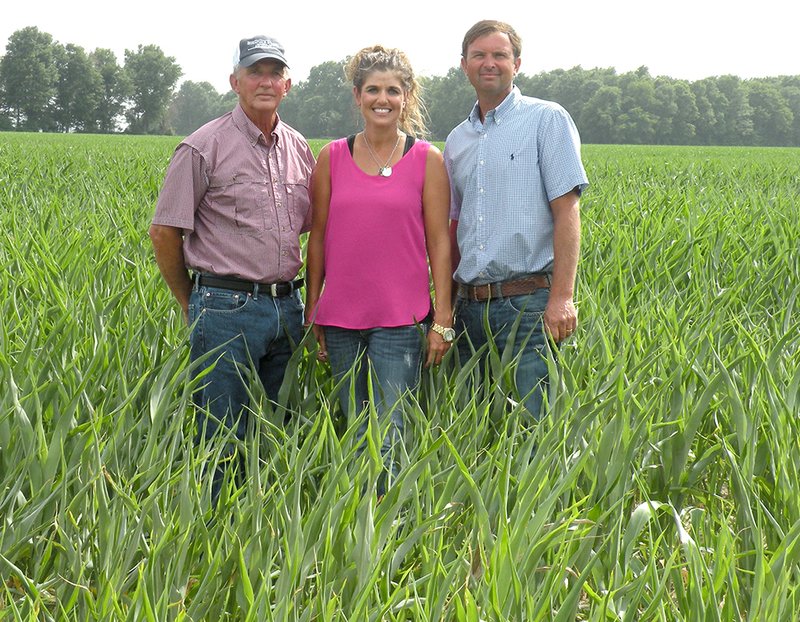 Kenny Clark, left, stands with his daughter, Micahlene Clark Soden, and his son, Jason Clark, in a field of milo on their farm in Grubbs.