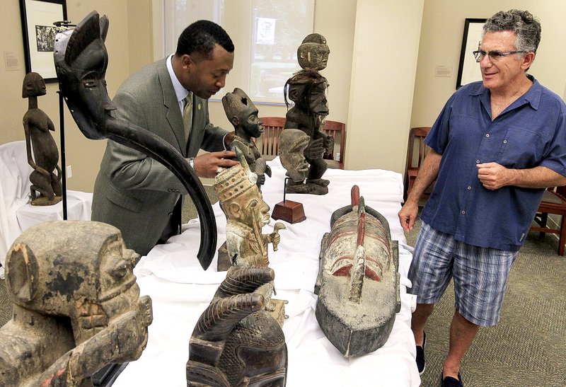 Roderick Smothers, (left) president of Philander Smith College in Little Rock, and Kevin Katz, an African-art collector from Dickinson, Texas, talk Friday about some of the masks and statues Katz and his wife, Melissa, donated to the college.