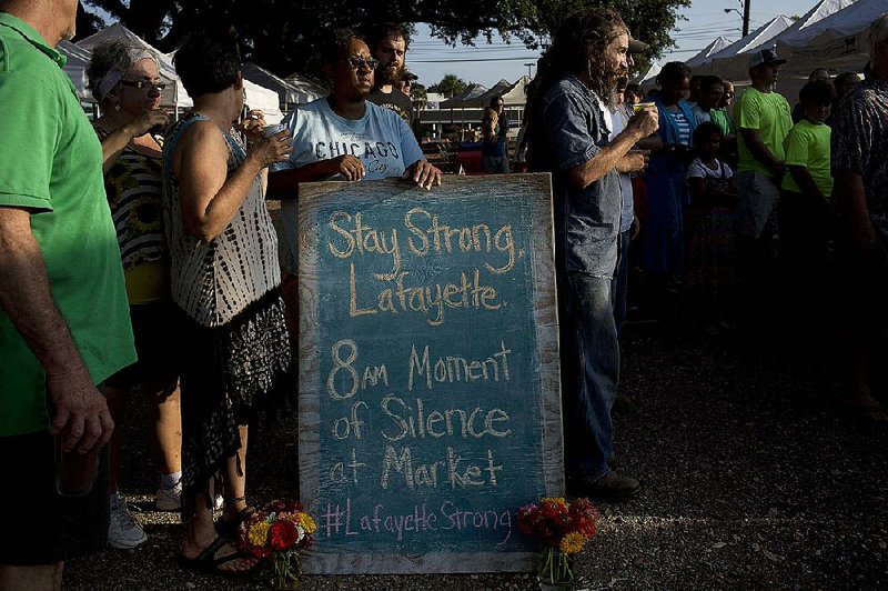 A crowd gathers at a farmers market Saturday in Lafayette, La., to hold a moment of silence for the victims of Thursday night’s theater shooting. 