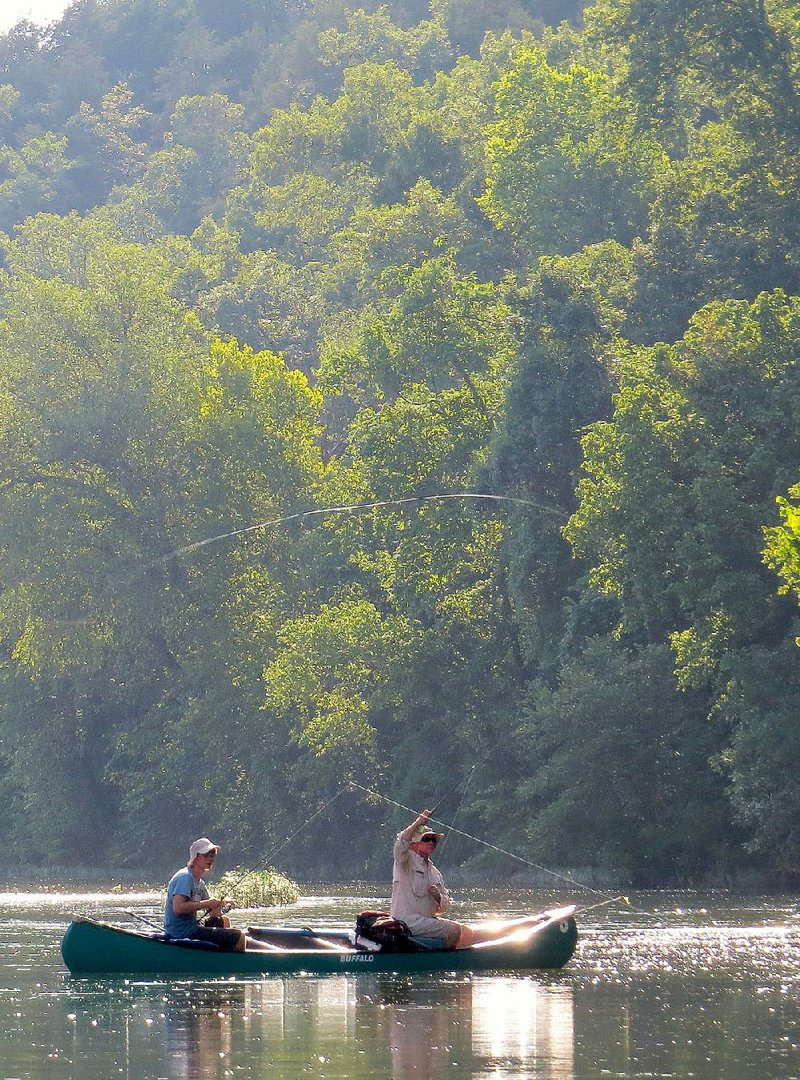Matthew Hendricks (left) fishes a crankbait, while Rusty Pruitt casts a fly Thursday evening on Crooked Creek. 