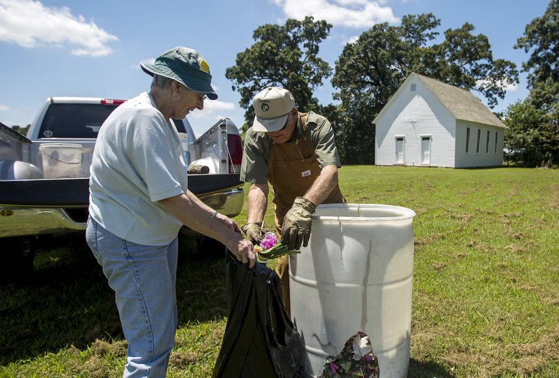 Nola and her husband Jeff Moser clean up trash outside Mount Hebron Church in Rogers in this July 16 file photo. A campaign to restore the church started in the mid-1990s, said Cassie Elliott of the Mount Hebron Church & Cemetery Historical Preservation Association. The church was added to the National Register of Historic Places in 2003.