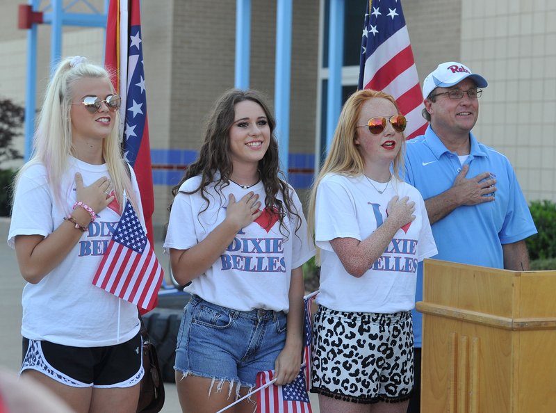 Caroline Kutchka (from left), Celine Nardi, Victoria McCutchen and Joey McCutchen lead the crowd in the Pledge of Allegiance on Friday at Southside High School during a rally about the decision to change the Fort Smith’s school’s mascot.