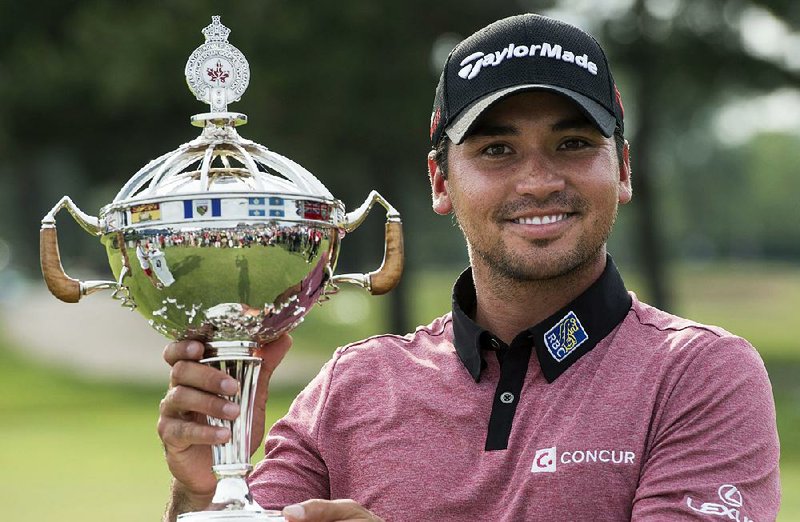 Jason Day holds up the trophy Sunday after winning the Canadian Open golf tournament in Oakville, Ontario.