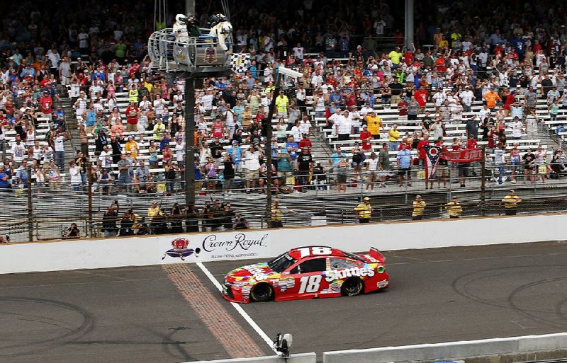 Kyle Busch crosses the finish line to capture the NASCAR Sprint Cup’s Brickyard 400 at Indianapolis Motor Speedway on Sunday. Busch also took the checkered flag in the Xfinity Series race at the track Saturday, completing a weekend sweep in Indianapolis.