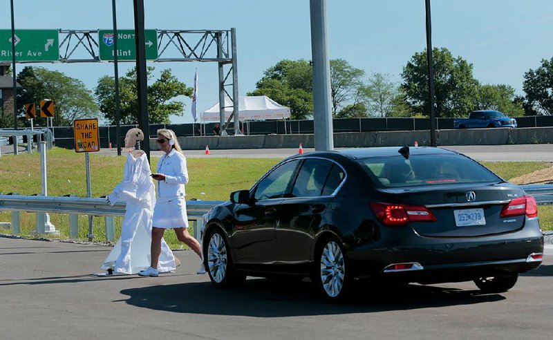 An automated 2015 Honda Acura stops for a human pedestrian and Sebastian, a mechatronic pedestrian, during a test at the University of Michigan’s North Campus Research Complex.