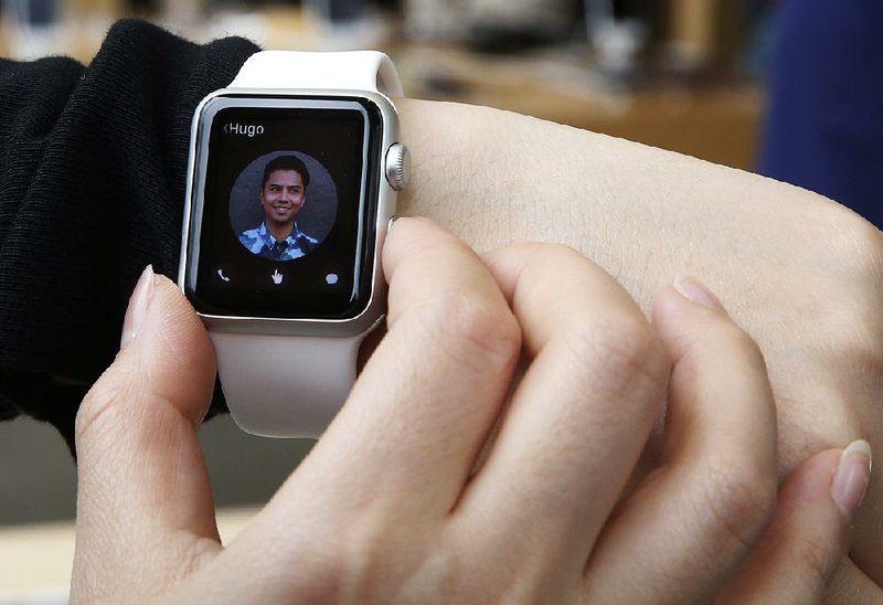 In this April file photo, a customer tries on an Apple Watch at an Apple Store in Hong Kong.