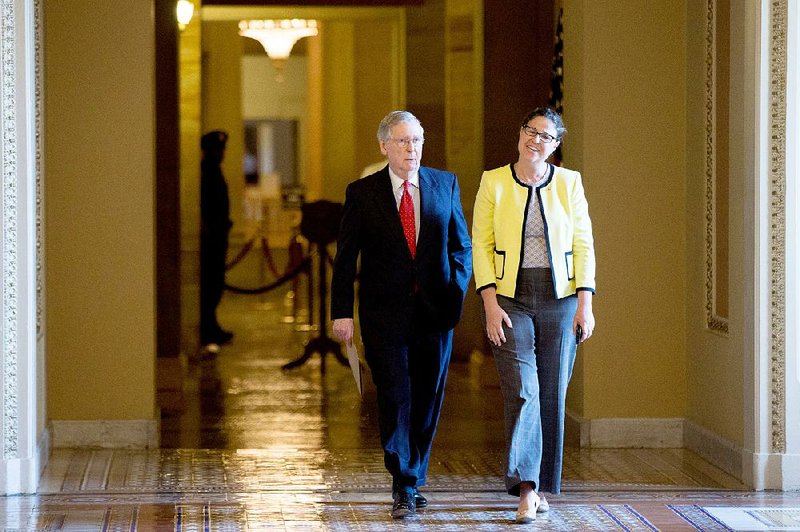 Senate Majority Leader Mitch McConnell, accompanied by Secretary for the Majority of the Senate Laura Dove, heads into the Senate chamber as the Senate convenes for a Sunday session on Capitol Hill in Washington.