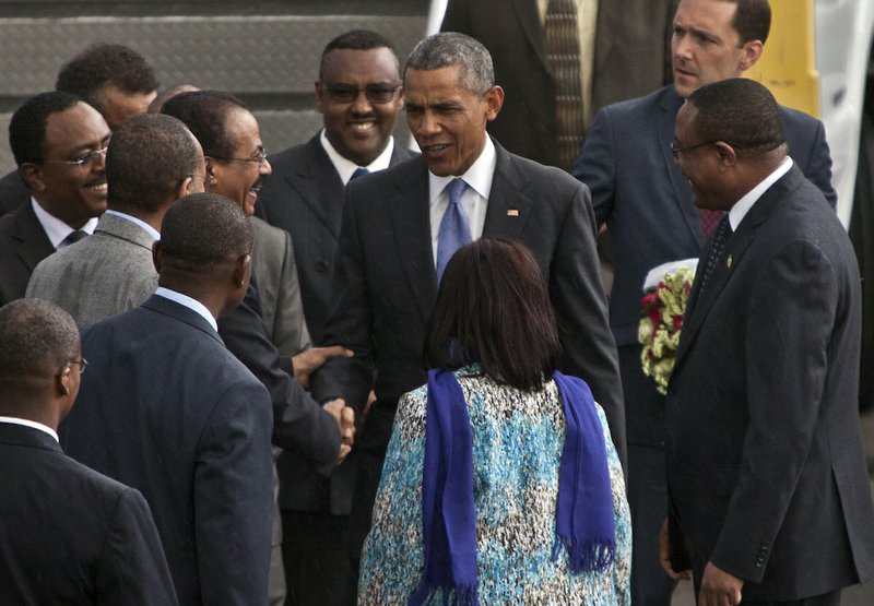 U.S President Barack Obama, center, meets Ethiopian officials as Ethiopian prime minister Hailemariam Desalegn, right, watches at Bole International Airport, Addis Ababa, Ethiopia, Sunday, July 26, 2015. Obama is traveling on a two-nation African tour where he will become the the first sitting U.S. president to visit Kenya and Ethiopia.