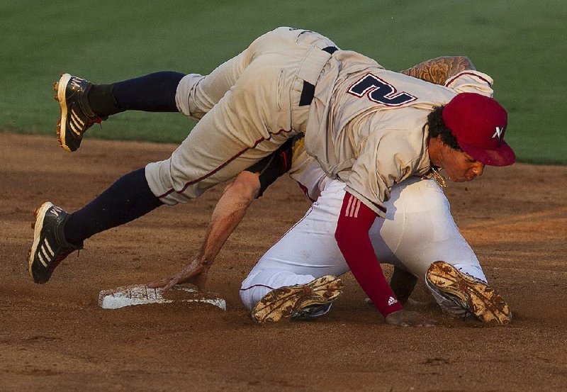 Northwest Arkansas Naturals shortstop Raul Mondesi (left) falls over the top of Drew Maggi of the Arkansas Travelers after tagging him out during the second inning of Monday’s night’s game. The Travelers picked up their fifth victory in a row by beating the Naturals 4-3 in front of 2,779 at Dickey-Stephens Park in North Little Rock.