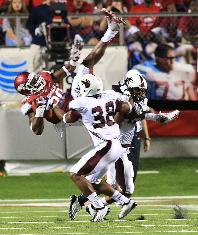 Louisiana-Monroe safety Mitch Lane (38) upends Arkansas tight end Chris Gragg after Gragg caught a pass during a game at War Memorial Stadium in Little Rock in 2012. Lane, a Pine Bluff native, is now a senior at Louisiana-Monroe, where he had 91 tackles last season for the Warhawks.