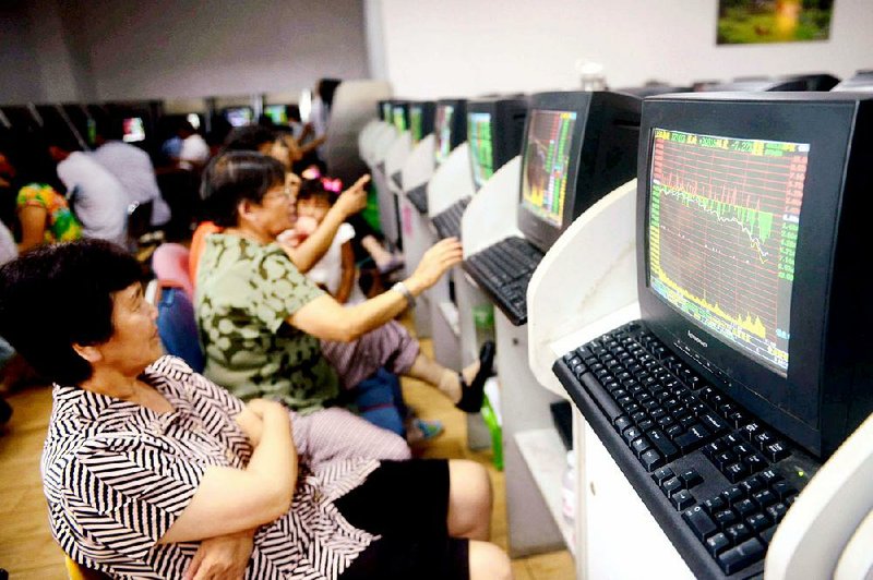 Investors follow stock price quotations Monday in Qingdao in east China’s Shangdong province. The Shanghai composite fell 345.35 points Monday with about 1,800 listings falling by the daily limit of 10 percent.