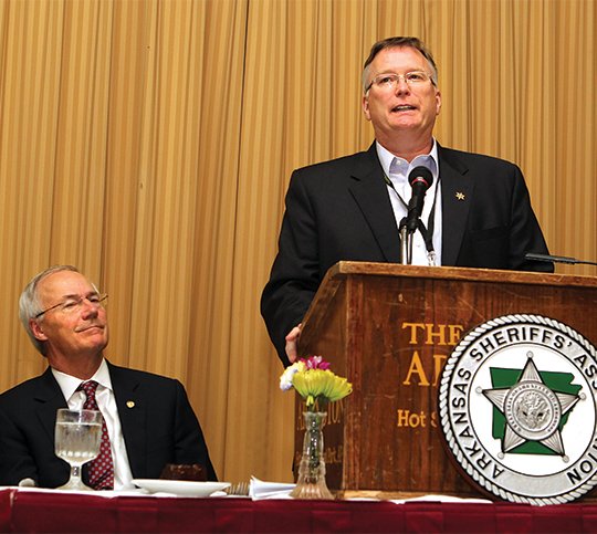 The Sentinel-Record/Beth Bright Sheriff's welcome: Gov. Asa Hutchinson, left, listens as Garland County Sheriff Mike McCormick welcomes members of the Arkansas Sheriffs' Association to Hot Springs Monday at the Arlington Resort Hotel & Spa. Hutchinson was the speaker at the luncheon.