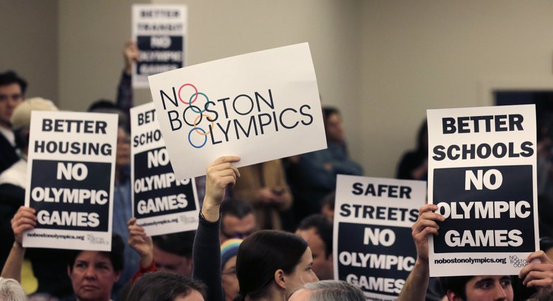 The Associated Press ACTIVE PROTEST: People hold up placards against the Olympic Games coming to Boston, during the first public forum regarding the city's 2024 Olympic bid, in Boston.