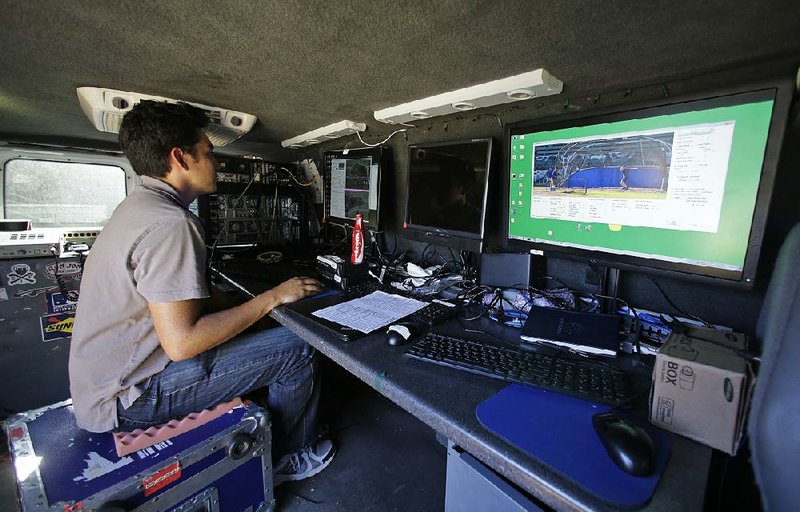 A technician tests a computerized video system that was being used to call balls and strikes in a minor-league baseball game Tuesday night and tonight at San Rafael, Calif. 