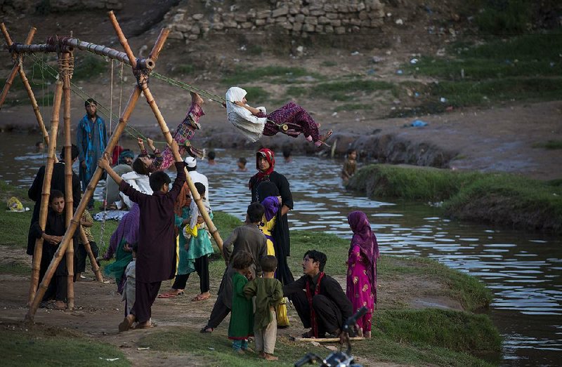 Pakistani children displaced from their villages because of fighting play on a swing set at a temporary home Tuesday in a suburb of Islamabad.