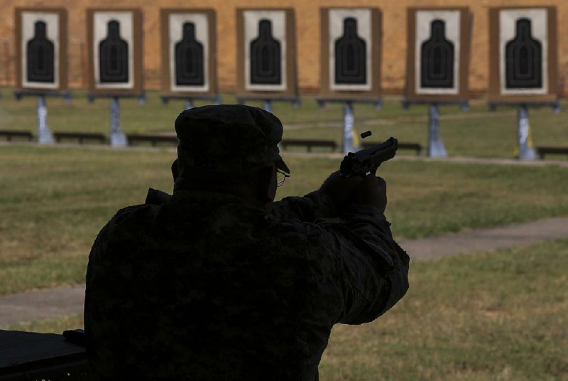 Staff Sgt. James Bell fires an M9 pistol on the range at Camp Robinson as part of firearms and use-of-force training in this Tuesday, July 28, 2015 file photo.