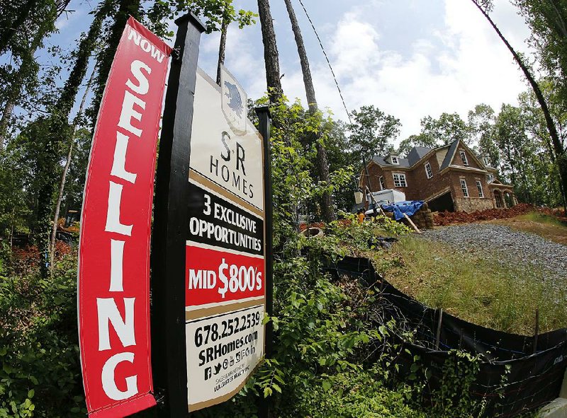 A sign advertises a home under construction in Roswell, Ga., in June. Home sales have risen recently as an improving economy is helping more people afford a house.