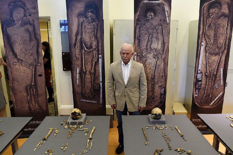 William Kelso, director of archaeology at Jamestown, Va., displays bone fragments of four of the earliest leaders of the settlement Tuesday at the Smithsonian’s National Museum of Natural History in Washington. Behind him are 3-D scans of the excavated graves.