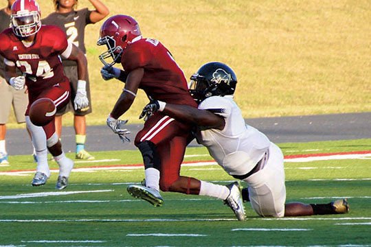The Sentinel-Record/Verlin Price UP FOR GRABS: Harding's Dennis Buckner forces a fumble from Henderson State receiver Corey Chappell (1) late in the fourth quarter, leading to a touchdown that gave the Bisons a 28-24 road victory over the two-time defending Great American Conference champion Reddies last October in Arkadelphia. Harding is picked second and Henderson State third behind defending GAC champion Ouachita Baptist in a preseason vote of league football coaches.