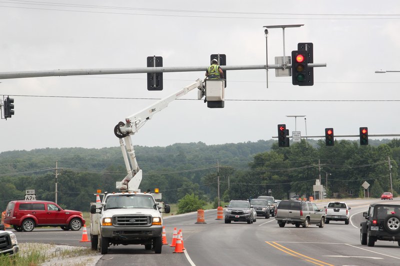 LYNN KUTTER ENTERPRISE-LEADER Crews with Arkansas Highway and Transportation Department work to move over one of the traffic signals for a new right-hand turn lane to go through Prairie Grove. The turn lane should open this week, workers said.