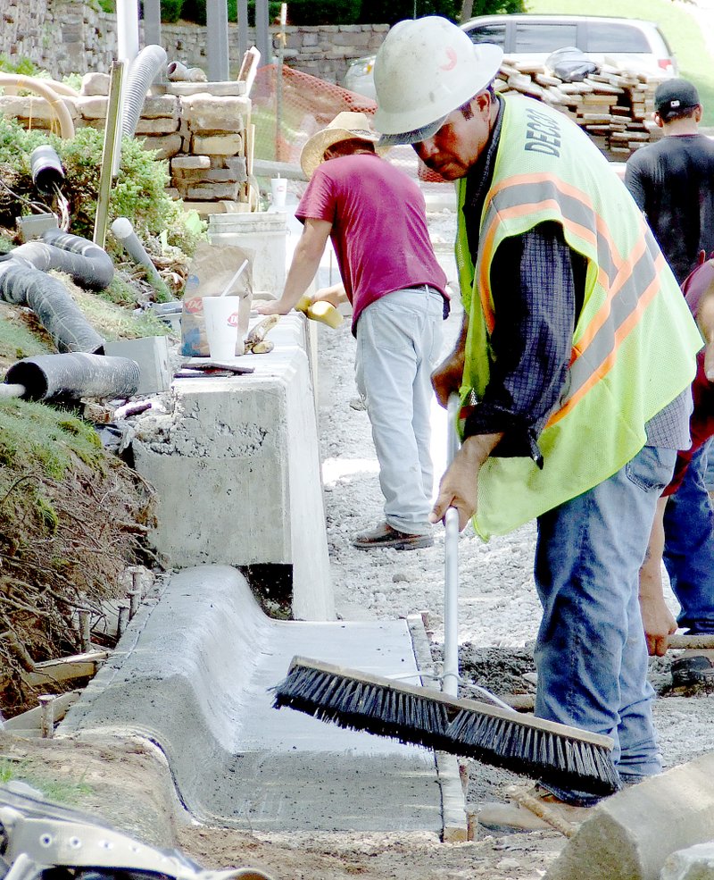 Tom A. Throne/The Weekly Vista Workers from DECCO Contractors of Rogers work on the curbing Friday, July 24, in the lower parking lot of the Bella Vista Country Club. The curbing is part of the ADA improvements being made at the BVCC.