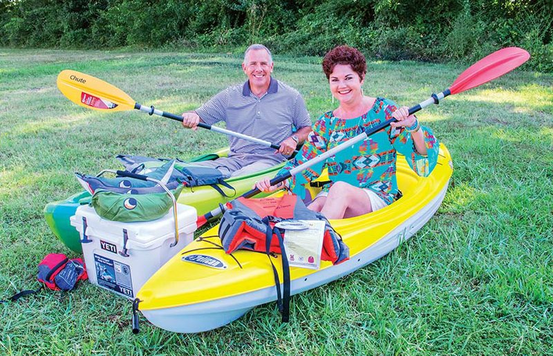 Greg Moix and Lisa Gamble sit in kayaks that will be raffled Aug. 8 during the auction part of the St. Joseph School Bazaar in Conway. The package also includes hammocks, a backpack and a Yeti cooler. The bazaar’s midway will open at 5:30 p.m. Friday and Saturday at the school on College Avenue. A new Ford F-150 pickup is being raffled and will be given away Saturday at the conclusion of midway activities.