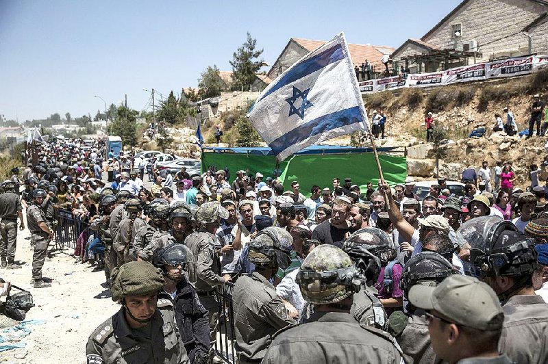 Israeli settlers gather during the demolition of a housing complex Wednesday at the Jewish settlement of Beit El near the West Bank town of Ramallah. 