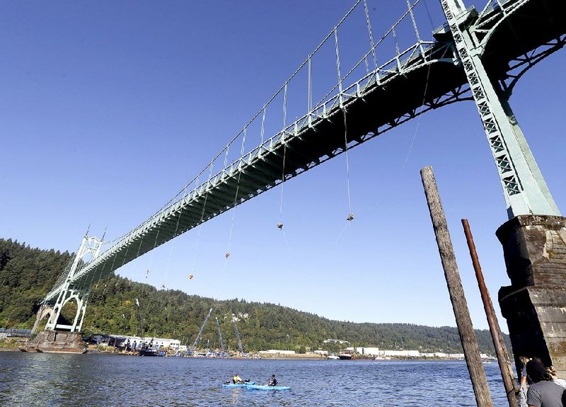 Activists hang from the St. Johns Bridge in Portland, Ore., on Wednesday in an attempt to stop a Royal Dutch Shell icebreaker from leaving the city.