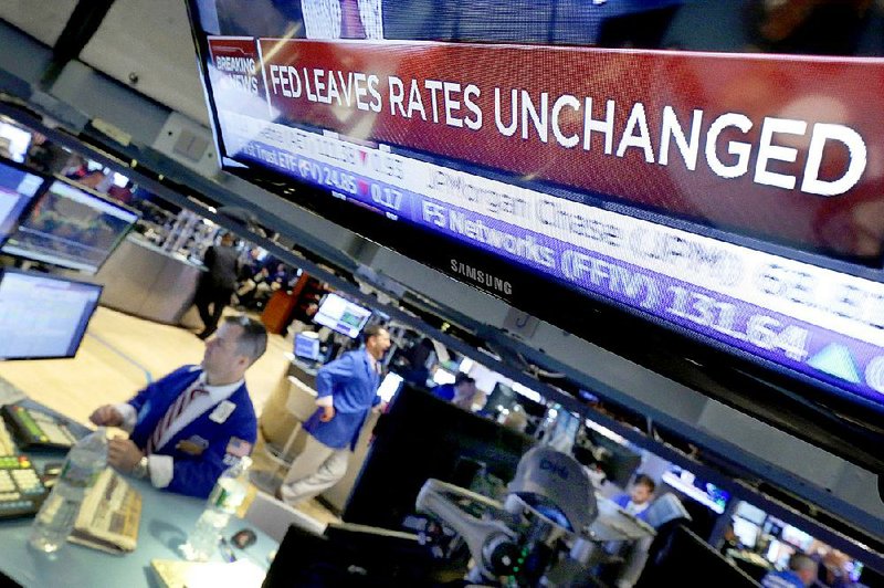 A headline on a TV monitor at the New York Stock Exchange announces the Federal Reserve’s decision Wednesday to leave interest rates unchanged. 