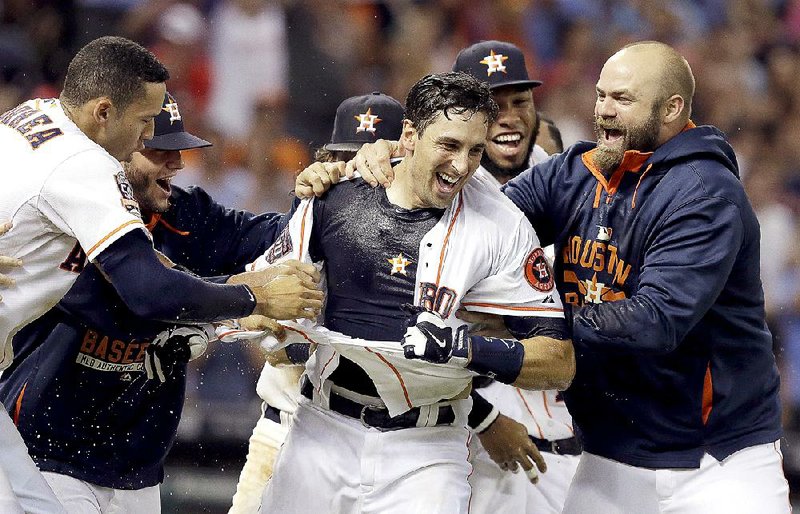 Houston catcher Jason Castro (center) celebrates with teammates after hitting a game-winning three-run home run in the bottom of the ninth inning to beat the Los Angeles Angels 3-0 on Thursday.