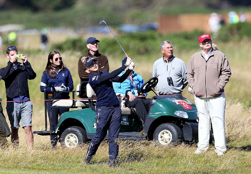 Republican presidential contender Donald Trump (far right) watches England’s Charley Hull (center) play her shot on the 16th hole during the first round of the Women’s British Open on Thursday at Trump’s Turnberry Ailsa Course in Turnberry, Scotland.