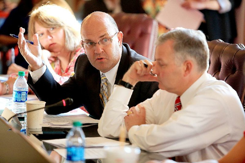 Jonathon Guthrie (center), principal at Bentonville’s Lincoln Junior High, speaks Thursday during a meeting of the Governor’s Council on Common Core Review, along with Lt. Gov. Tim Griffin (right) and Searcy parent Kay Giddens.