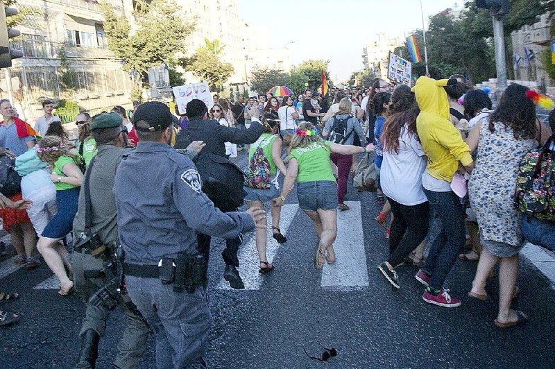 Israeli police chase suspect Yishai Schlissel through the crowd Thursday at a gay pride parade in Jerusalem. Six people were stabbed before Schlissel, an ultra-Orthodox Jew, was subdued. 