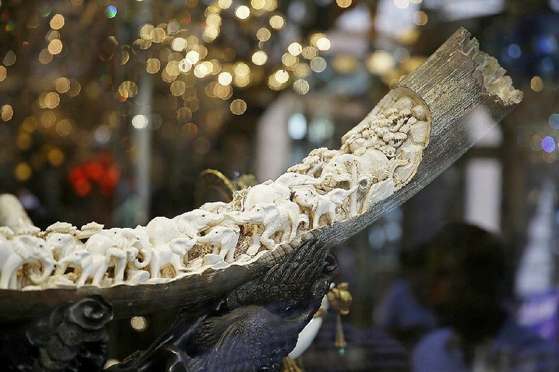 Carvings of elephants and other animals are shown inside a mammoth ivory tusk for sale in the window of a Chinatown shop in San Francisco last week. Merchants of carved ivory tusks and trinkets in San Francisco’s Chinatown wonder what effect President Barack Obama’s new order restricting ivory sales will have in California, the country’s No. 2 market for elephant ivory.