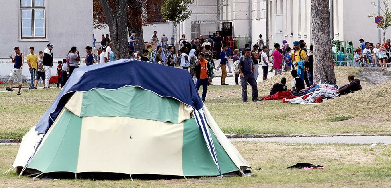 Foreigners wait outside a camp Friday in Traiskirchen, Austria. Austria is working on a plan in which the federal government would shelter asylum seekers on government property. 