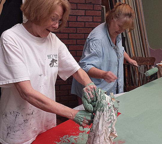 Submitted photo COLORFUL CONSERVATION: Florence Davis, left, and Maureen Godfrey work on painting theatrical flats for the upcoming Hot Springs Village Players production of "Young Frankenstein," the musical. Auditions for the play will be held Aug. 16 and 17.