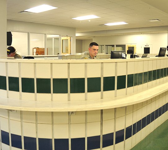 The Sentinel-Record/Mara Kuhn BOOKING AREA: Deputies Paul Steier, left, and Michael Stone work Friday in the booking area of the Garland County Detention Center. Arkansas Department of Correction inmates accounted for 56 of the 270 inmates held by the facility this week.