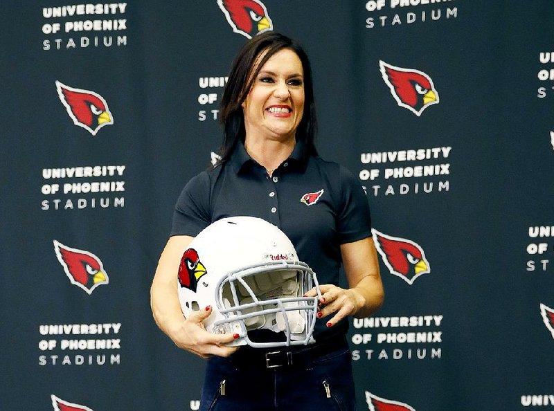 Dr. Jen Welter poses for photographers after being introduced July 28 at the Arizona Cardinals training camp in Tempe, Ariz.