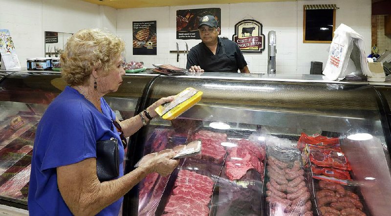 A butcher waits on a shopper at a grocery store in the Little Havana neighborhood of Miami in June. U.S. consumer spending in June rose the smallest amount since February.