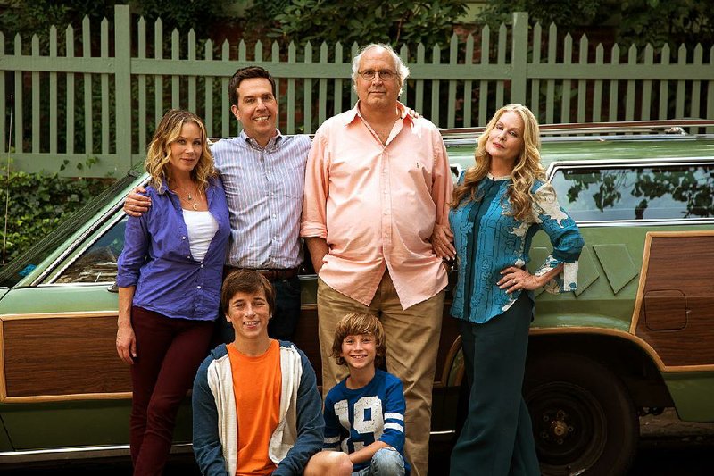 Christina Applegate (standing, from left), Ed Helms, Chevy Chase, Beverly D’Angelo and Skyler Gisondo (kneeling, left) and Steele Stebbins appear in a scene from "Vacation." In Hollywood’s laziness, the movie industry has increasingly turned to reviving classic comedies. The latest attempt is "Vacation," a new try at the 1983 classic "National Lampoon film starring Chase. He makes a cameo in the latest "Vacation."