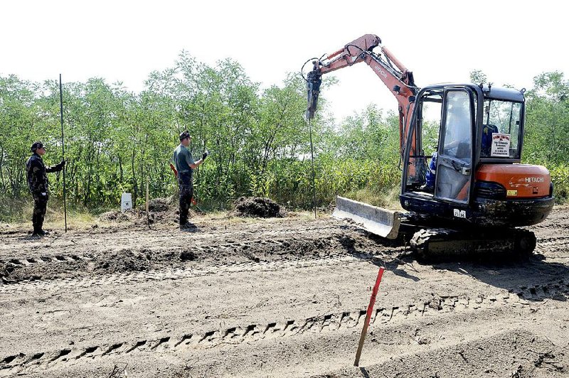 Hungarian soldiers watch a ringing-machine drive steel posts into the earth as they construct a temporary fence on Hungary’s southern border with Serbia near Morahalomon Monday.