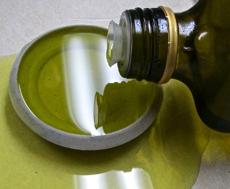 Olive oil overflows a dipping dish.