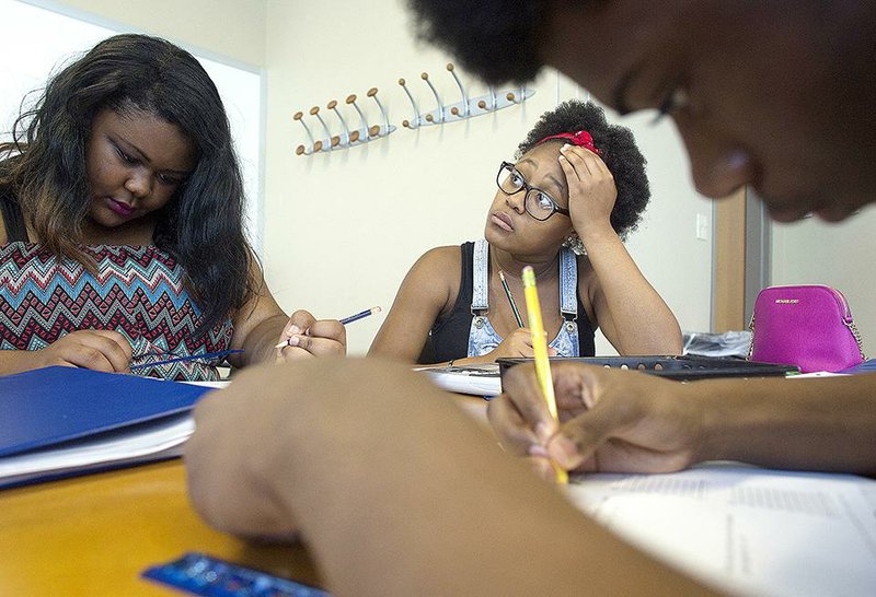 Dominique Wilson, 16, (right), a student at Maumelle High School, listens to instruction during a calculus prep course Thursday with Denesha Wilburn, 16, (left), a student at J.A. Fair High School, and Justin Harper, 16, a student at Hall High School. The students attended Arkansas AIMS’ first Summer PREP (PreAP Readiness for Eager People) workshop at the University of Arkansas at Little Rock.